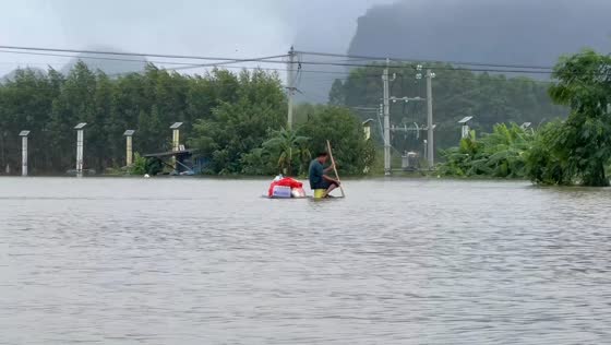Man calmly paddles homemade raft through floodwaters in Guangxi, China