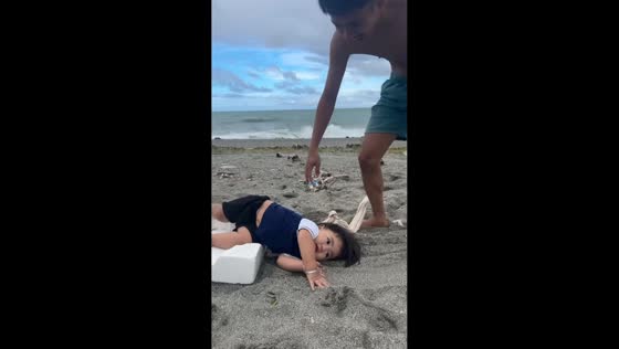 Adorable toddler rides makeshift styrofoam sled at Nabas beach, Aklan, Philippines