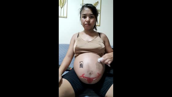 Pregnant woman wipes off face drawing on tummy in Batangas, Philippines