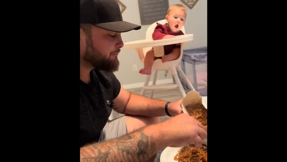 Baby mimics eating gesture while observing others in Florida