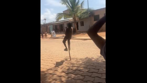 Children in Parakou hop with single stick to show their culture