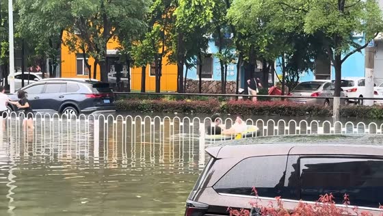 Pedestrian slips into floodwater while avoiding flooded road in Liaoning, China