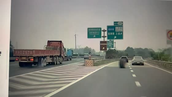 Loose truck tire rolls across the highway after detaching from a flatbed truck in Sichuan, China