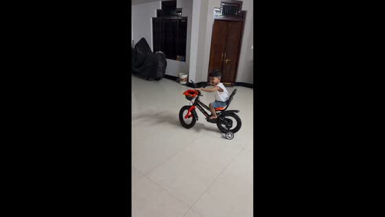 Boy drifts bicycle with training wheels in Uttar Pradesh, India
