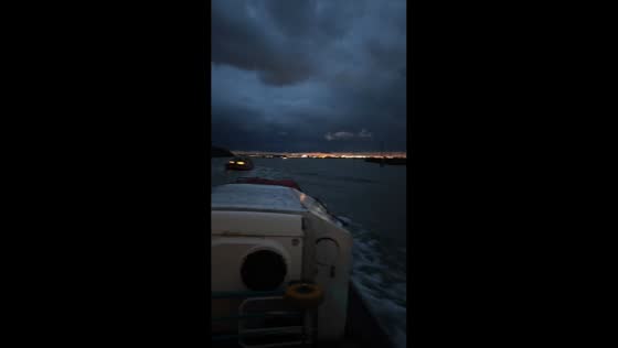 Boats navigate rough, dark waters under stormy skies in Venice, Italy