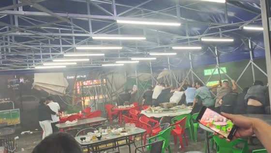 Strong storm winds send diners rushing to secure patio canopy in Shandong, China