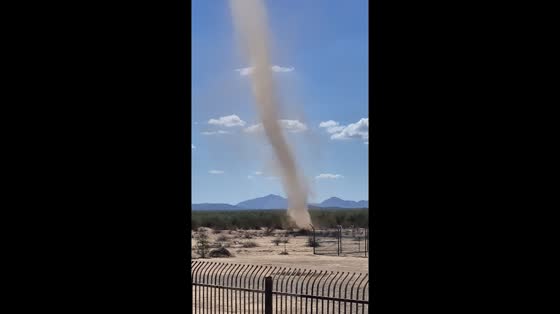 Dust devil forms near water tower in San Simon, Arizona, USA