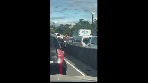 Impatient lady in Philippines walks through heavy traffic