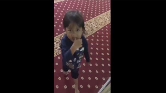 Unintentional collision: young girl in mosque runs into pillar while being recorded