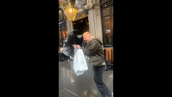 Man battles against strong wind in Edinburgh, Scotland