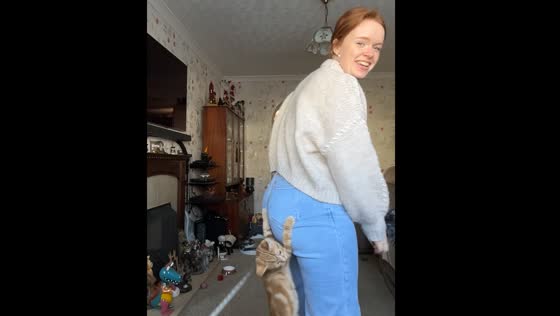 Cat climbs onto person while they explain measurements for jeans