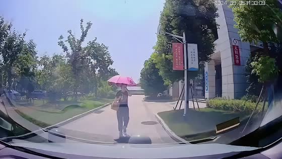 Woman trips over curb while walking with umbrella in Anhui, China