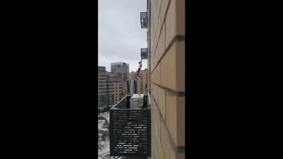 Young man hangs on air conditioner fence in Tyumen, Russia