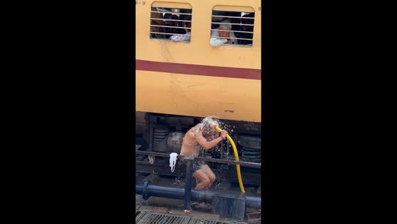 Man casually bathes beside train at railway station in Patna, India